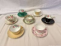 Front angled view showing all seven tea cup and saucer sets