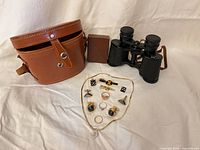 Binoculars, leather case, accessory box and spread of jewelry
