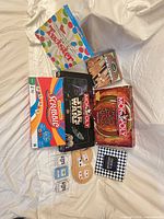 All listed board games, cribbage boards, card decks laid out on blanket