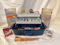 Front view of tackle box with packaged hooks, line, bait jars and leather sheath