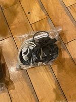 Bagged assortment of USB cables on wooden floor