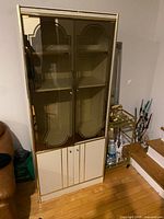 Front view of the white laminate display bookcase showing smoked glass upper doors and lower panel doors
