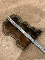Top view of cement silhouette tray with tape measure indicating length