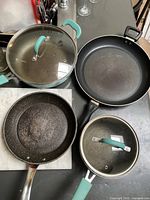 Top view of all four cookware pieces showing lids and interiors