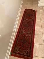 Full view of red patterned runner rug on tiled floor