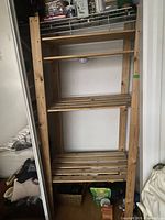 Full view of wooden shelf unit in closet showing overall structure and contents