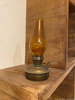 Front view of amber glass chimney and metal base gas lamp