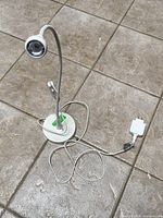 Full view of lamp showing base, stem, head and cord