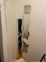 Two wavy mirrors mounted on wall