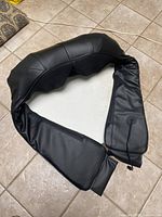 massager laid flat showing U-shape, straps, mesh panel