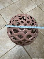 Top view showing lattice pattern and measuring tape across sphere