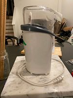 Left side view of popcorn maker showing clear chute, power cord and overall condition