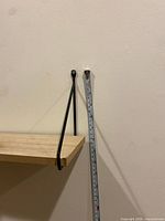 Shelf board attached to wall, vertical tape for scale