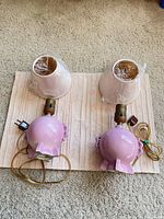 Two pink Stangl lamp bases with wrapped shades displayed on mat