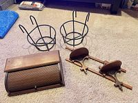 Overview showing bread box, two wire baskets, wooden gun rack on carpet