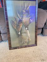 Front view of framed print showing game animals and frame detail