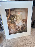 Front view showing photographic print of exit door with foliage, mat and frame