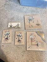 Group shot of five sand paintings on carpet