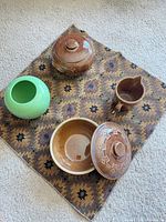 Group of four pottery pieces on patterned mat