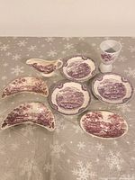 overview of all eight purple transferware pieces on table