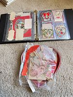Binder open showing sleeved vintage Valentines and heart-shaped box lid with bag of additional cards
