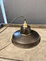 Top view of black metal pendant showing cord and socket