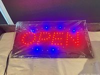 Front view illuminated showing red OPEN text and blue border LEDs