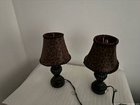 Two small table lamps with leopard shades and dark bases