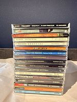 Stack of jewel cases showing 15 visible spines including Radiohead, R.E.M., Public Enemy etc.