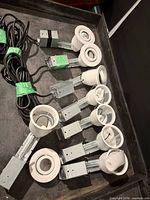 Eight recessed light assemblies laid out showing white trims, metal boxes and wiring