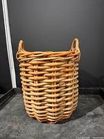 Front view of cylindrical woven wood basket with handles