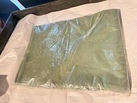 Front view of sealed package showing sage woven placemats