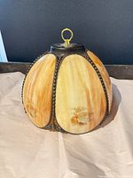 Front view of dome shade showing amber and ivory panels, metal frame, hanging loop