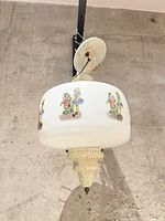 Full view of pendant showing shade, painted figures, finial, canopy and chain