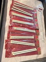 Eight sealed short white tension rods and one longer rod laid out