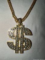 Close-up of dollar sign pendant with clear stones