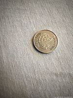 Obverse side showing pin-up and “HEADS I WIN” text