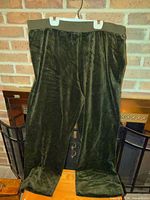Front view of army green velvet pants hanging