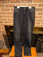 Front view of black ripped jeans hanging