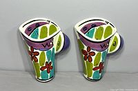 Front view of both ceramic wall pockets showing design and colors