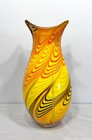 Front view of yellow-orange swirl Murano style glass vase