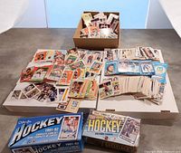 Overview of loose hockey cards in stacks, two sealed O-Pee-Chee boxes visible