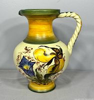 Front view showing floral painting and twisted handle