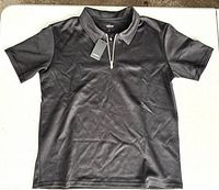 Front view of black short-sleeve quarter-zip shirt with tag attached