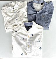Overview of three folded shirts showing colors, patterns and styles