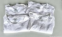 Four folded white Polo Ralph Lauren T-shirts