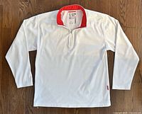 Front view of white long-sleeve 1/4-zip pullover with red inner collar