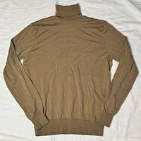 Back view of gold Merino wool turtleneck sweater laid flat