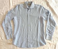Front view of blue Suitsupply dress shirt laid flat showing overall style and condition