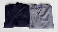 Both folded sweaters, navy and grey, front view
